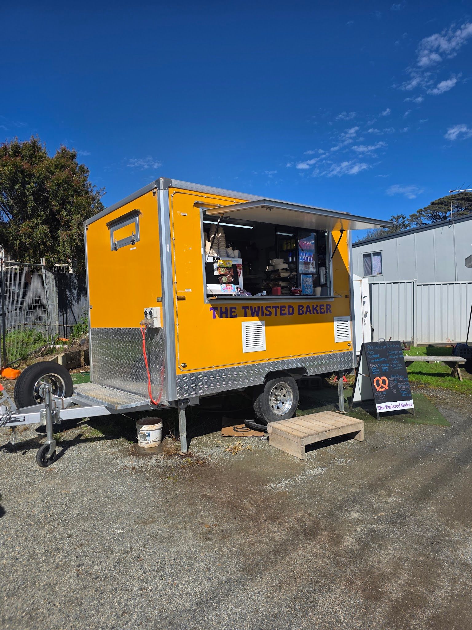 The Twisted Baker yellow food truck in Surf Beach on a sunny day